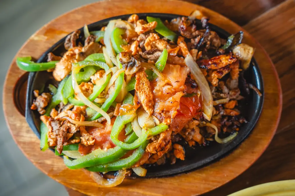 Chicken fajitas with peppers and onions on a cast iron skillet